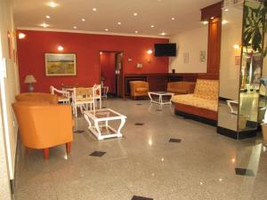 Hotel Luey في بوينس آيرس: غرفة معيشة مع كنب وطاولة وكراسي