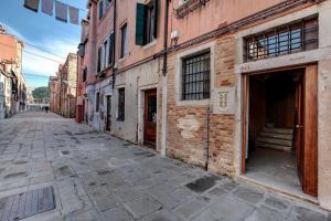 an empty street in an old city with a brick building at Biennale superior suite in Venice
