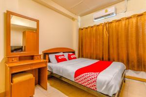 - une chambre avec un lit, une commode et un miroir dans l'établissement OYO 583 Sweethome Guest House, à Bangkok Noi