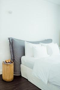 Heirloom Hotels - A Flemish Tale في خنت: سرير ابيض ومخدات بيضاء وطاولة خشبية