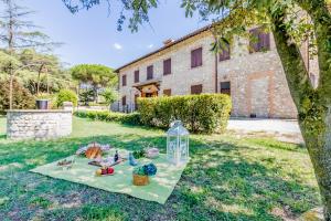 a picnic table in the grass in front of a building at Scappo in Umbria, Casale Rosceto in Todi