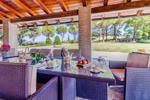 an outdoor dining area with a table and chairs at Gorgeous 2-storey villa with a large private pool in Todi