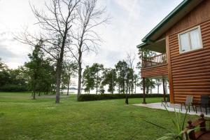 una casa con un patio verde al lado de un edificio en Chalets et Spa Lac Saint-Jean en Chambord