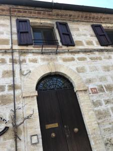 un edificio con una porta in legno e tre finestre di Casa Veronica Ancona ad Ancona