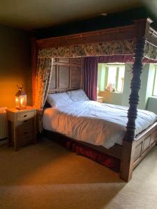 ein Schlafzimmer mit einem großen Bett mit einem hölzernen Baldachin in der Unterkunft North Shire in Liverton