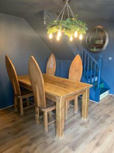 a wooden dining room table with chairs and a chandelier at North Shire in Liverton