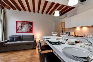 a kitchen and living room with a table and a couch at Cannaregio suite with garden in Venice