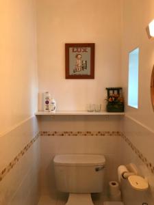 uma casa de banho com WC e uma prateleira na parede em The Bridges Bed and Breakfast em Donegal