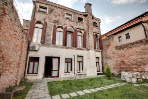an old brick building with red doors and windows at Cannaregio suite with garden in Venice