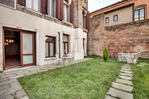 a courtyard of a building with a table and chairs at Cannaregio suite with garden in Venice