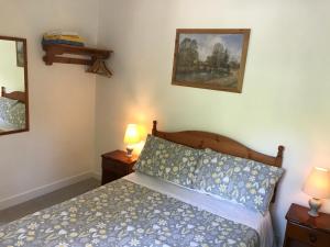 1 dormitorio con 1 cama y 2 lámparas en las mesas en The Bridges Bed and Breakfast en Donegal