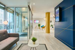 a living room with a couch and a table at Residence Mercure Paris La Defense Grande Arche in Nanterre