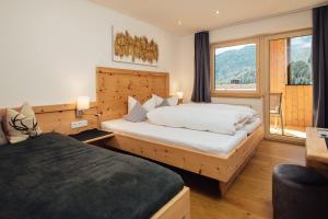 a hotel room with two beds and a large window at Haus Piz Lad in Nauders