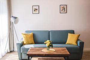 a blue couch with yellow pillows and a table at Mathias Rex in Szentendre