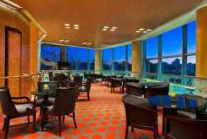 a dining room with tables and chairs and windows at Quinto Centenario Hotel in Córdoba
