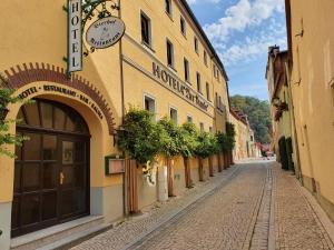 Una calle vacía al lado de un edificio con un reloj. en Hotel Zur Traube, en Freyburg