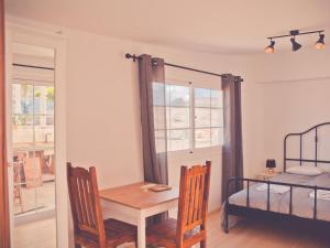 a room with a table and chairs and a bed at Gartenappartement - Tierra - Surf & Yoga Villa in La Pared