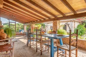 un patio al aire libre con una mesa azul y sillas en Villa Can Sol, en Pollensa