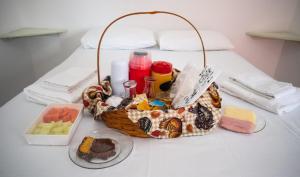 a basket of food and a plate of food on a table at Urbano Suítes in Ubatuba