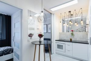 a kitchen with white cabinets and white appliances at Crystal Apartment Katowice III in Katowice