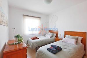 a bedroom with two beds and a desk and a window at Vivienda Vacacional Dolphin in Tías +23 photos