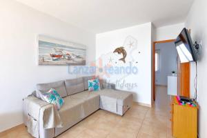 a living room with a couch and a tv at Vivienda Vacacional Dolphin in Tías