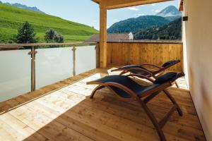 a chair on a deck with a view of mountains at Haus Piz Lad in Nauders