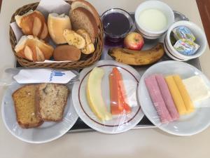una bandeja de diferentes tipos de pan y fruta en Hotel Riviera Lins, en Lins