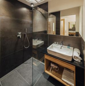 a bathroom with a sink and a glass shower at Haus Piz Lad in Nauders