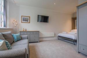 a living room with a couch and a bed at ChocoLets - The Foss Suite in York