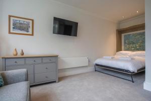 a bedroom with a bed and a dresser with a tv at ChocoLets - The Foss Suite in York