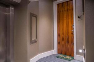 a bedroom with a bed next to a wooden door at ChocoLets - The Foss Suite in York