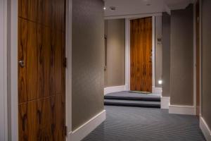 an empty hallway with a wooden door and a room at ChocoLets - The Foss Suite in York
