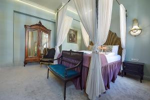 - une chambre avec un lit à baldaquin, une chaise et un miroir dans l'établissement Inner Blossom, à Kaunas