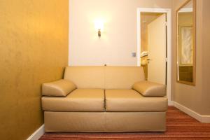 a couch in a room with a light on the wall at Hotel Bellevue Saint-Lazare in Paris +37 photos