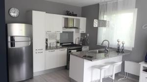 La cuisine est équipée de placards blancs et d'un réfrigérateur en acier inoxydable. dans l'établissement Apartamento Estrella Dominicus, à La Laguna