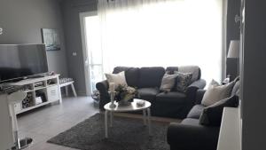 een woonkamer met een bank, een tv en een tafel bij Apartamento Estrella Dominicus in La Laguna