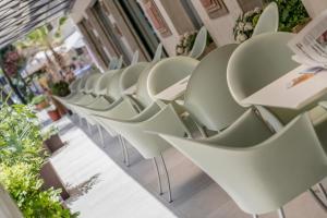 eine Reihe weißer Stühle in einem Gebäude in der Unterkunft Hotel Cristina Corona in Cattolica