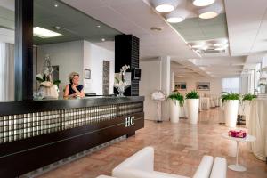 a woman standing behind the counter of a hair salon at Hotel Cristina Corona in Cattolica