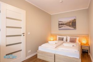 Cama ou camas em um quarto em Apartamenty BlueSky - Karkonoska 13, blisko szlaków i wyciągów