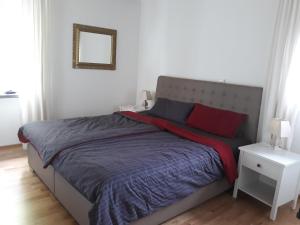 Schlafzimmer mit einem großen Bett mit blauer und roter Bettwäsche in der Unterkunft Paradiesli am Hochrhein in Rheinfelden