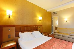 a hotel room with a bed and a couch at Hotel Bellevue Saint-Lazare in Paris