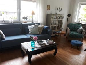 a living room with a blue couch and a coffee table at Paradiesli am Hochrhein in Rheinfelden