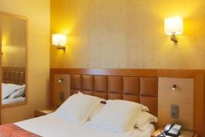 a hotel room with a bed and a telephone at Hotel Bellevue Saint-Lazare in Paris