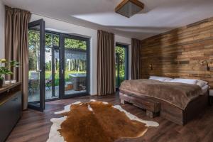 a bedroom with a large bed and a large window at Hotel Královka in Bedřichov