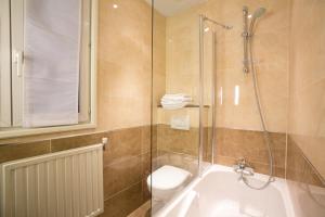 a bathroom with a shower and a toilet and a sink at Hotel Bellevue Saint-Lazare in Paris