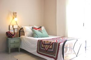 a bed with pillows and a blanket on it at Acogedor apartamento en EL VALLE DEL JERTE 1 in Piornal