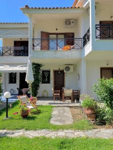 a house with a patio and a table and an umbrella at Stella's Maisonette in Siviri