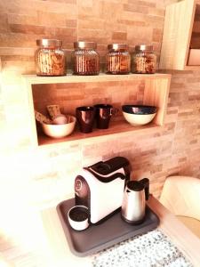 a coffee maker on a kitchen counter with bowls and jars at B&B Alghero Republic in Alghero