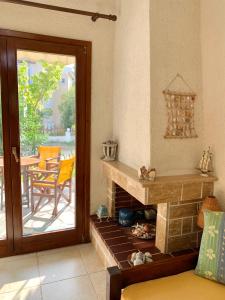 a living room with a fireplace and a sliding glass door at Stella's Maisonette in Siviri
